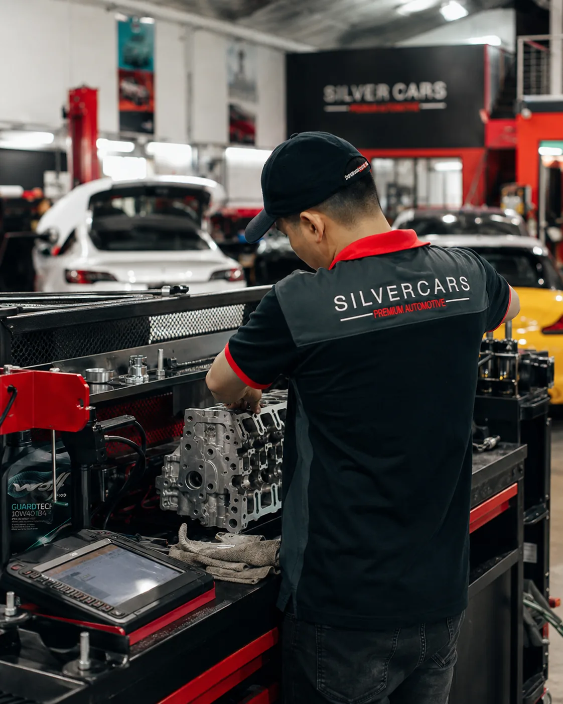 Técnico de Silver Cars trabajando sobre un componente de motor en el banco del taller.