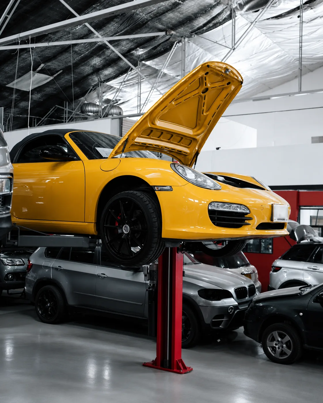 Porsche amarillo sobre el elevador del taller Silver Cars en Medellín.